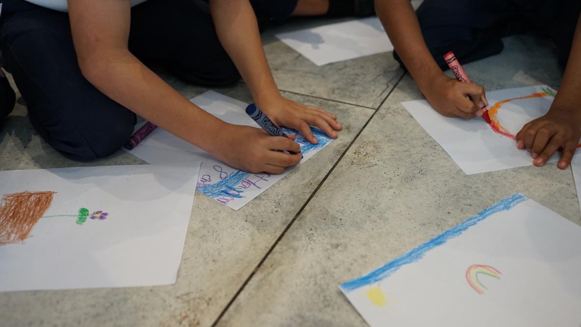 Children drawing with crayons at an art workshop
